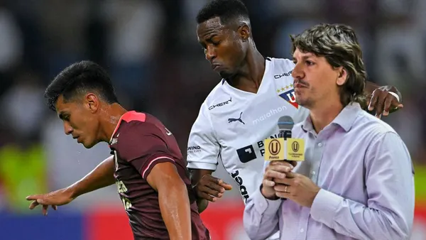 José Rivera disputando una acción de juego vs LDU y al lado Jean Ferrari