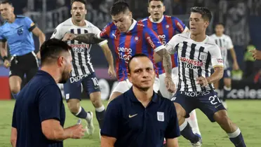Alejandro Restrepo mirando seriamente, mientras Catriel Cabellos pelea la pelota en la Copa Libertadores