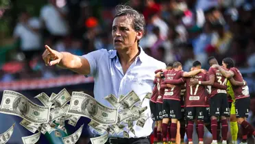 Fabián Bustos señalando y jugadores de Universitario de Deportes abrazados